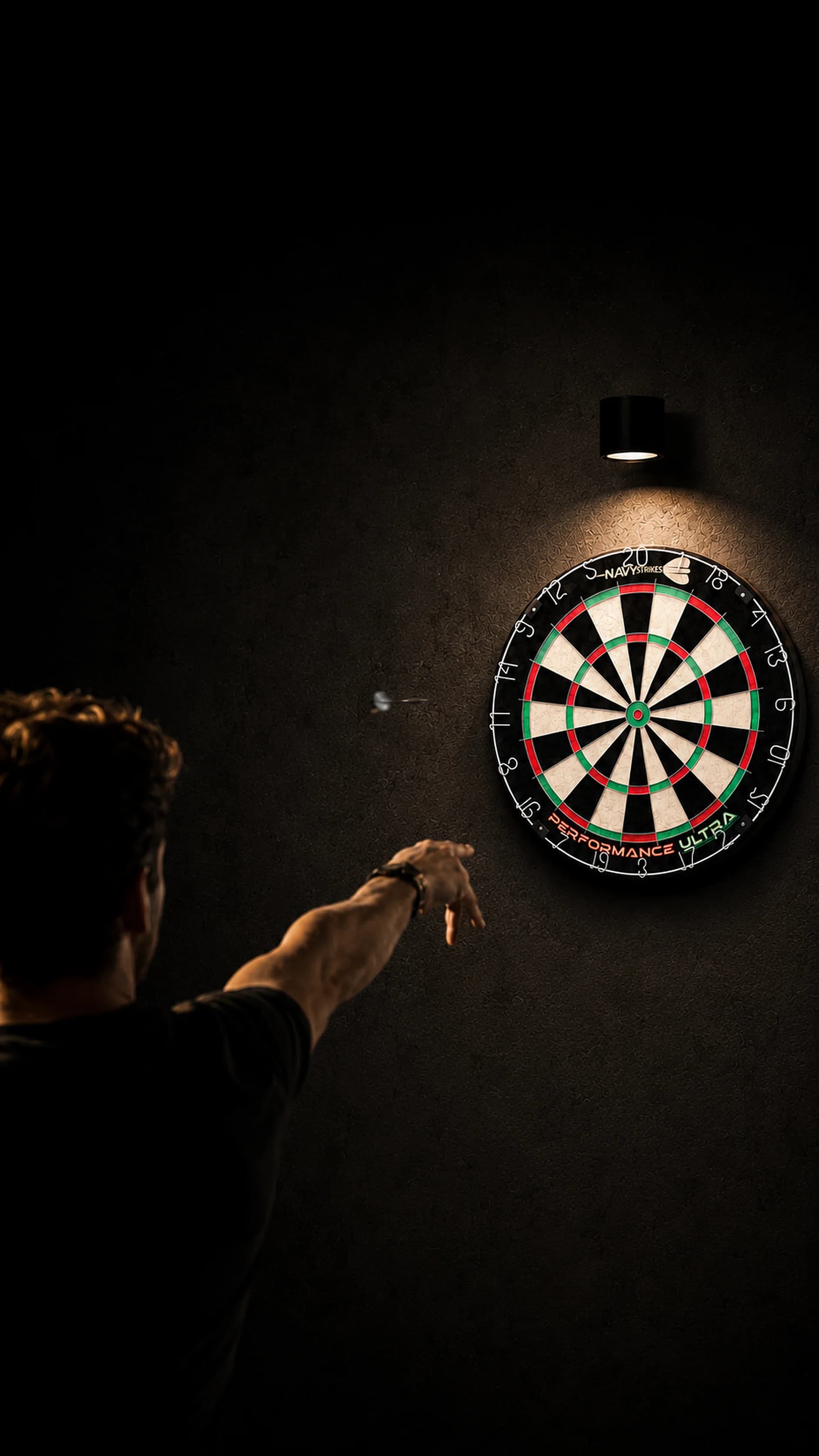 Darter gooit een pijl richting een Navy Strikes Performance Ultra dartbord in een sfeervol verlichte thuisruimte